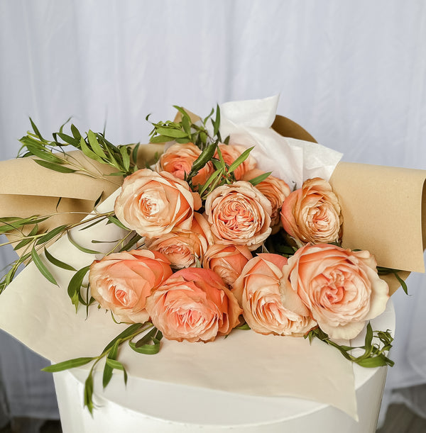 Kahala roses in color peach wrapped in craft paper
