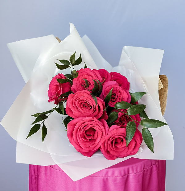 hot pink roses wrapped in craft paper