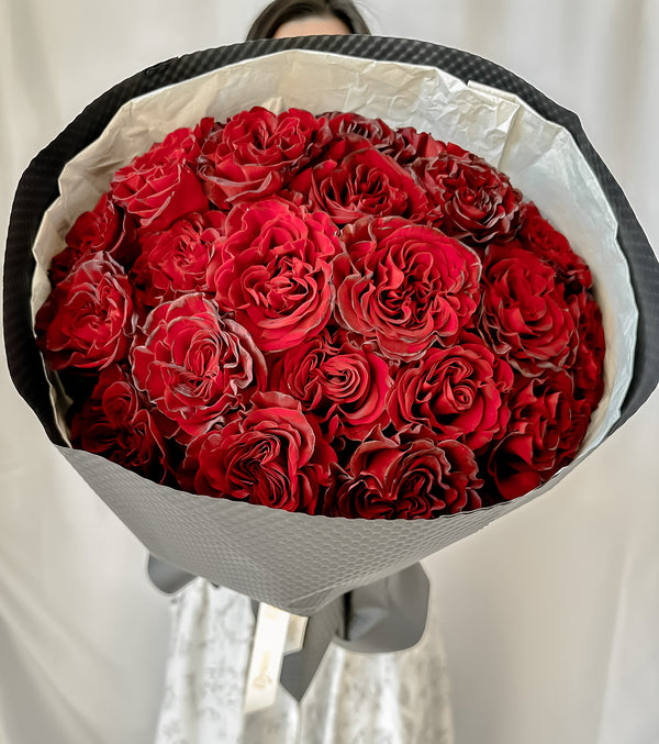 24 red heart big head roses wrapped in black elegance paper