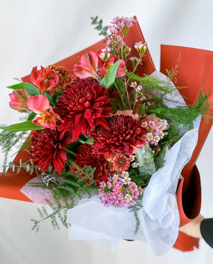 A collection of beautifully arranged floral bouquets with pink and red flowers, wrapped in matching red and white paper.