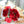 A bouquet of red roses with green eucalyptus leaves and curly willow, wrapped in white paper with a ribbon.
