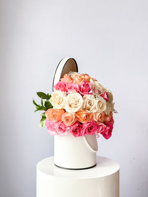 50 roses of tri color placed in a box with a string of pearls