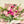 Bouquet of pink and purple flowers with greenery, wrapped in white paper.