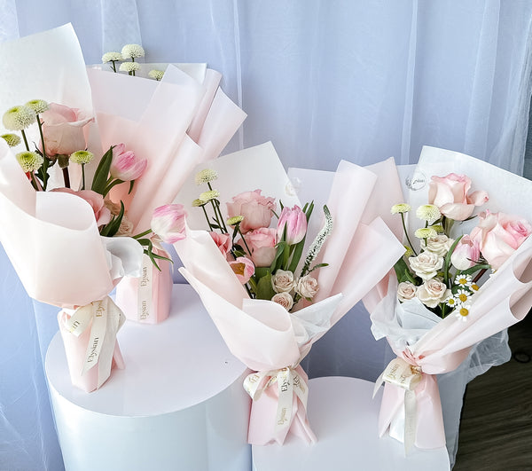 A collection of beautifully arranged floral bouquets with pink and white flowers, wrapped in matching pink and white paper.